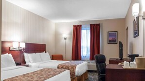 Quarto de hotel com duas camas, uma escrivaninha, uma cadeira, uma luminária de mesa, um quadro na parede e uma janela com cortinas.