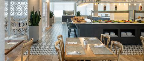 Un restaurante con barra central, mesas y sillas de madera.