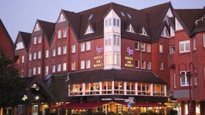 Un hotel con fachada roja, numerosas ventanas y un cartel que dice 'Hotel Market'.