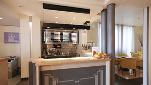 Un moderno vestíbulo de hotel con mostrador de recepción, zona de bar y asientos.