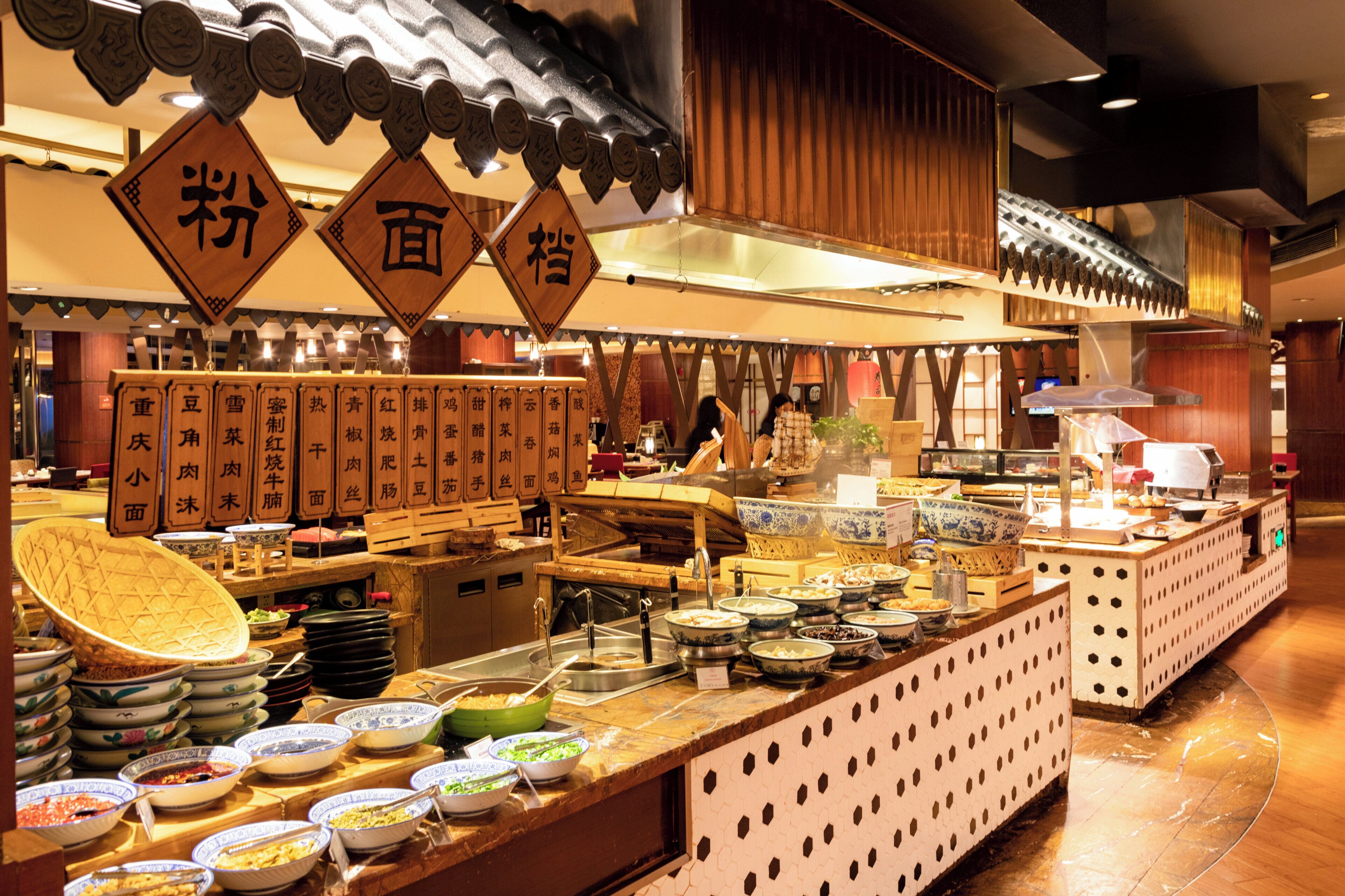 A buffet area with various dishes and a traditional Asian decor.