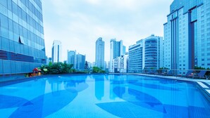 A swimming pool with a cityscape in the background. - Crowne Plaza Guangzhou City Centre by IHG (Guangzhou)