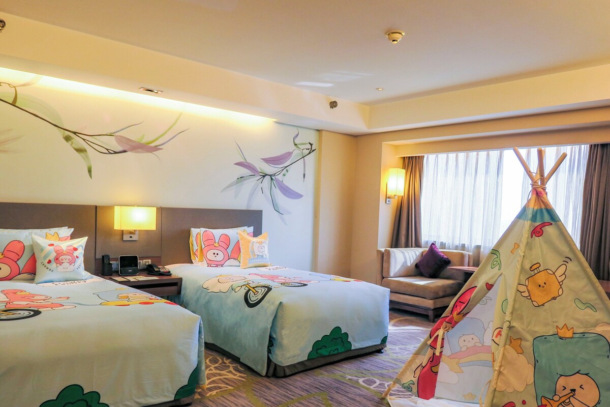 Habitación de hotel con dos camas, un escritorio, una silla, una lámpara, una ventana con cortinas y un tipi.