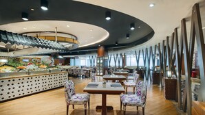 A restaurant with a central island, wooden tables, and chairs. - Crowne Plaza Guangzhou City Centre by IHG (Guangzhou)