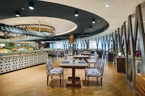 A restaurant with a central island, wooden tables, and chairs. - Crowne Plaza Guangzhou City Centre by IHG (Guangzhou)