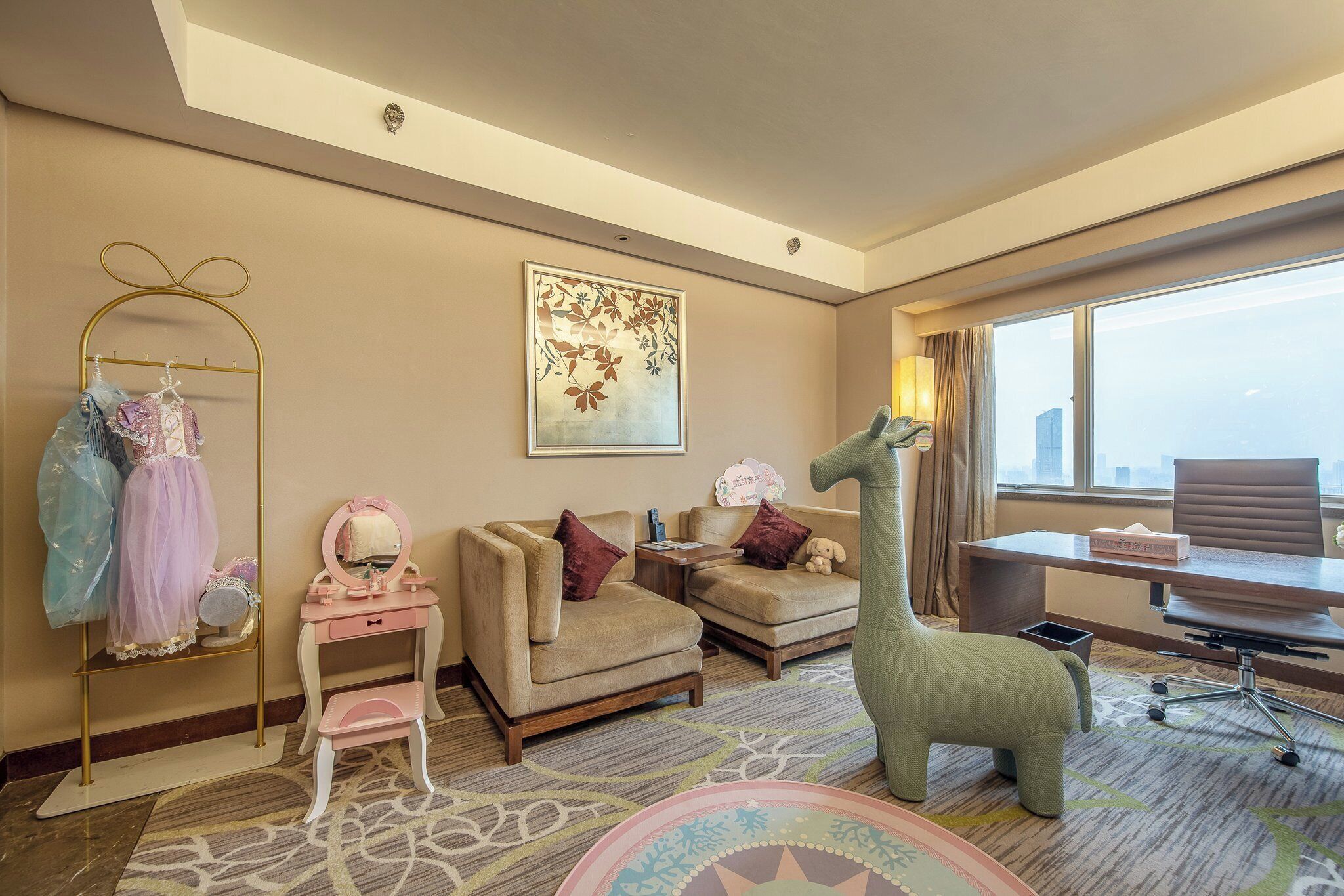 A hotel room with a sofa, armchair, desk, and a unique green animal-shaped chair.