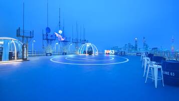 A spacious indoor area with a blue floor, a large circular structure in the center, and a sign reading "LINE 63".