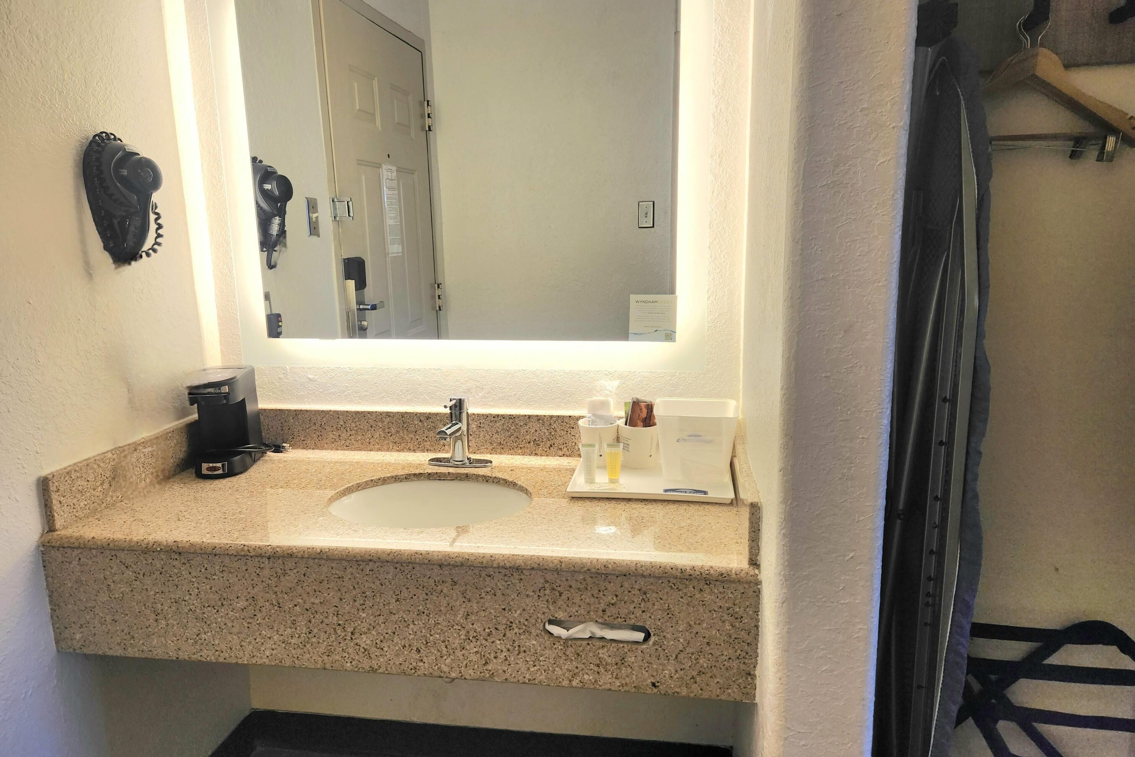 A bathroom with a sink, mirror, and towel rack.