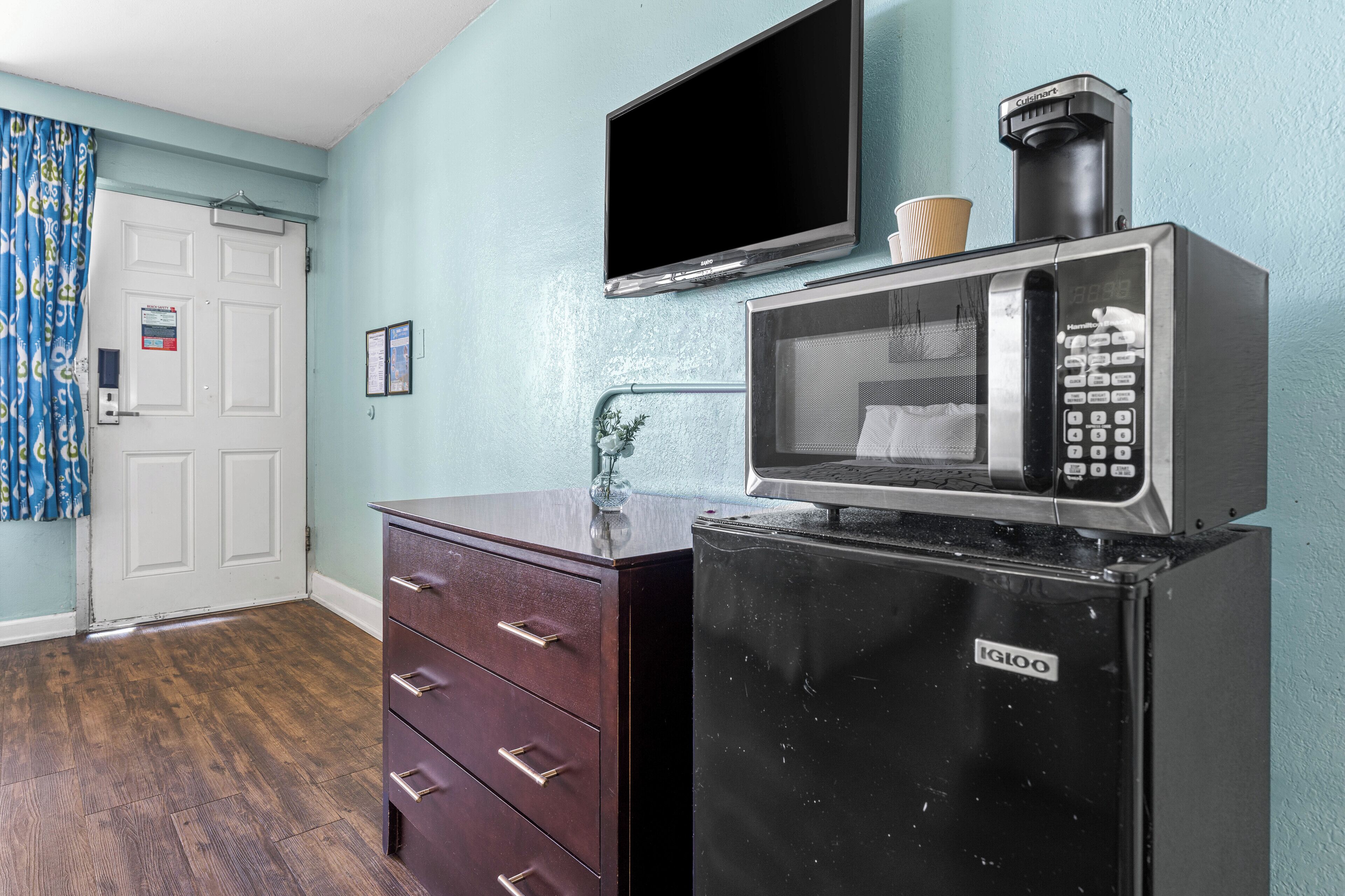 A compact kitchenette with a microwave, a coffee maker, and a small refrigerator.