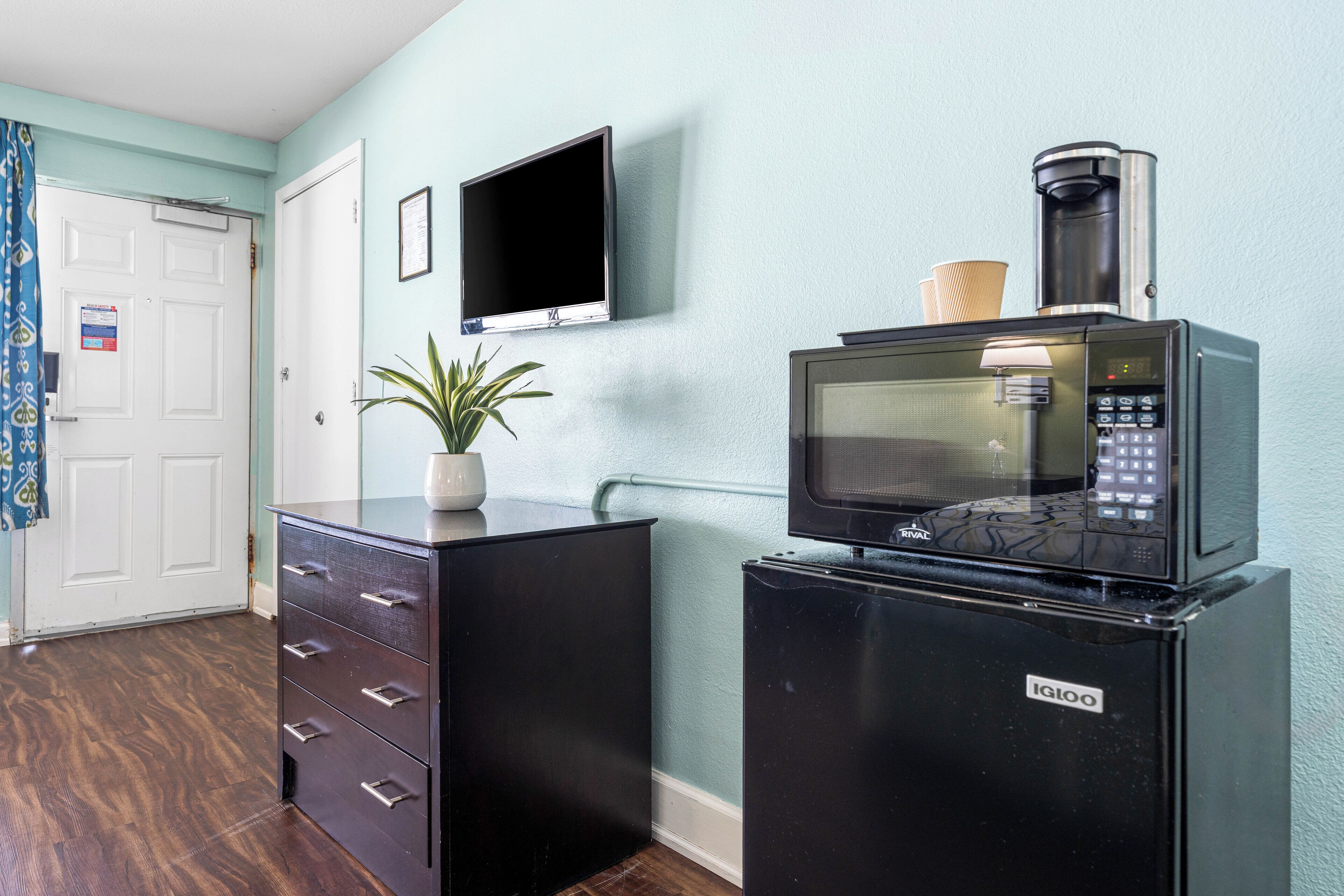 A compact kitchenette with a microwave, coffee maker, and a small refrigerator.