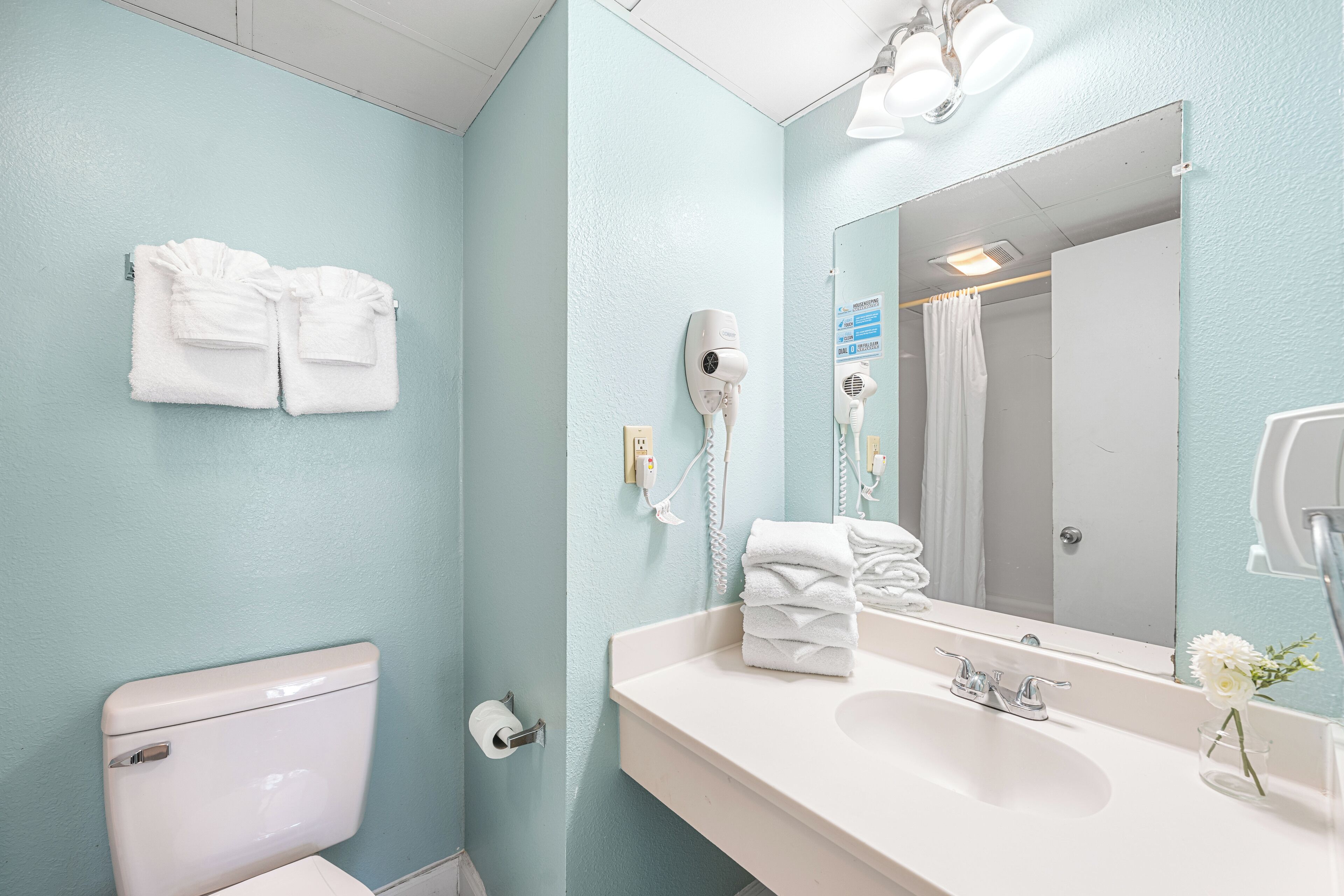 A bathroom with a toilet, sink, and towel rack.