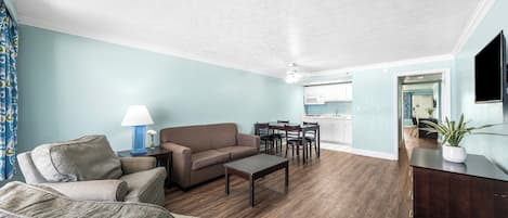 Una sala de estar con sofá, mesa de centro y comedor.