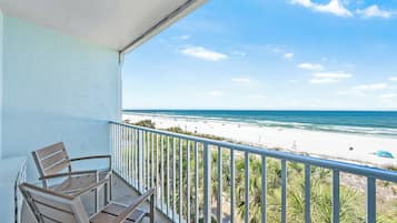A balcony with a view of a beach and ocean.