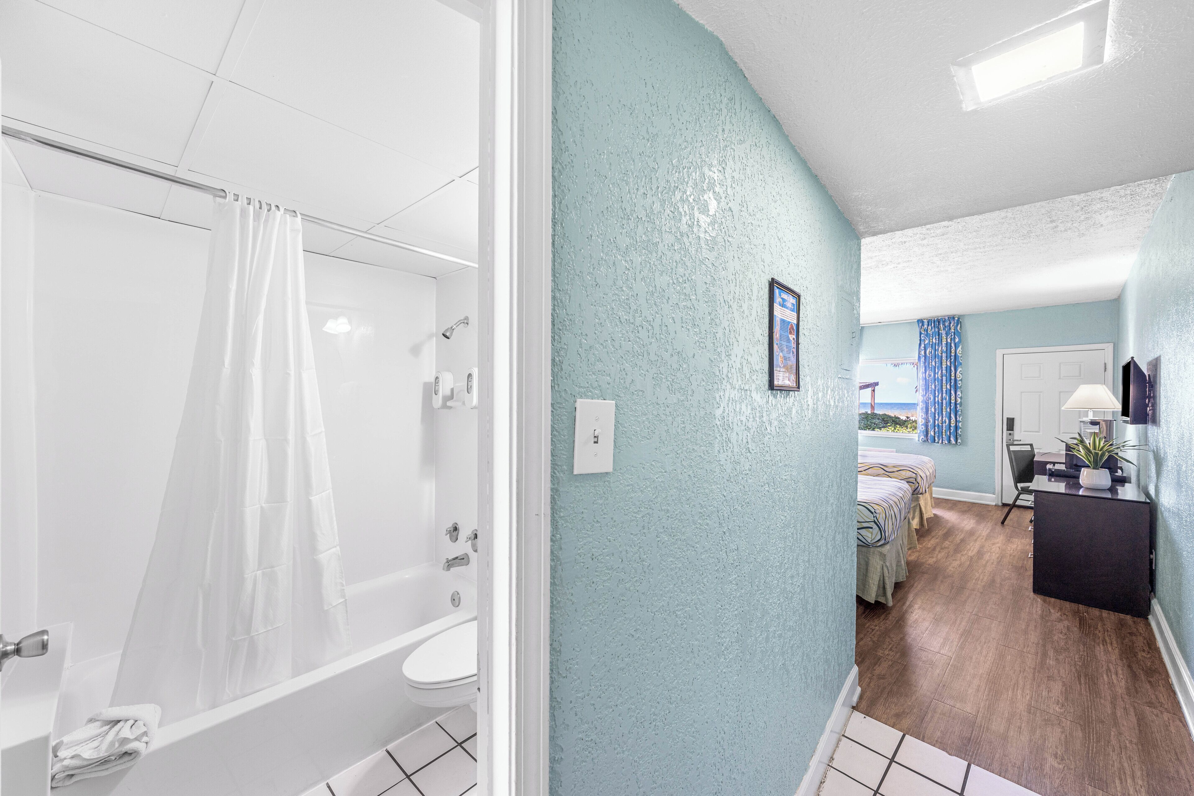 A bathroom with a bathtub, toilet, and shower curtain.