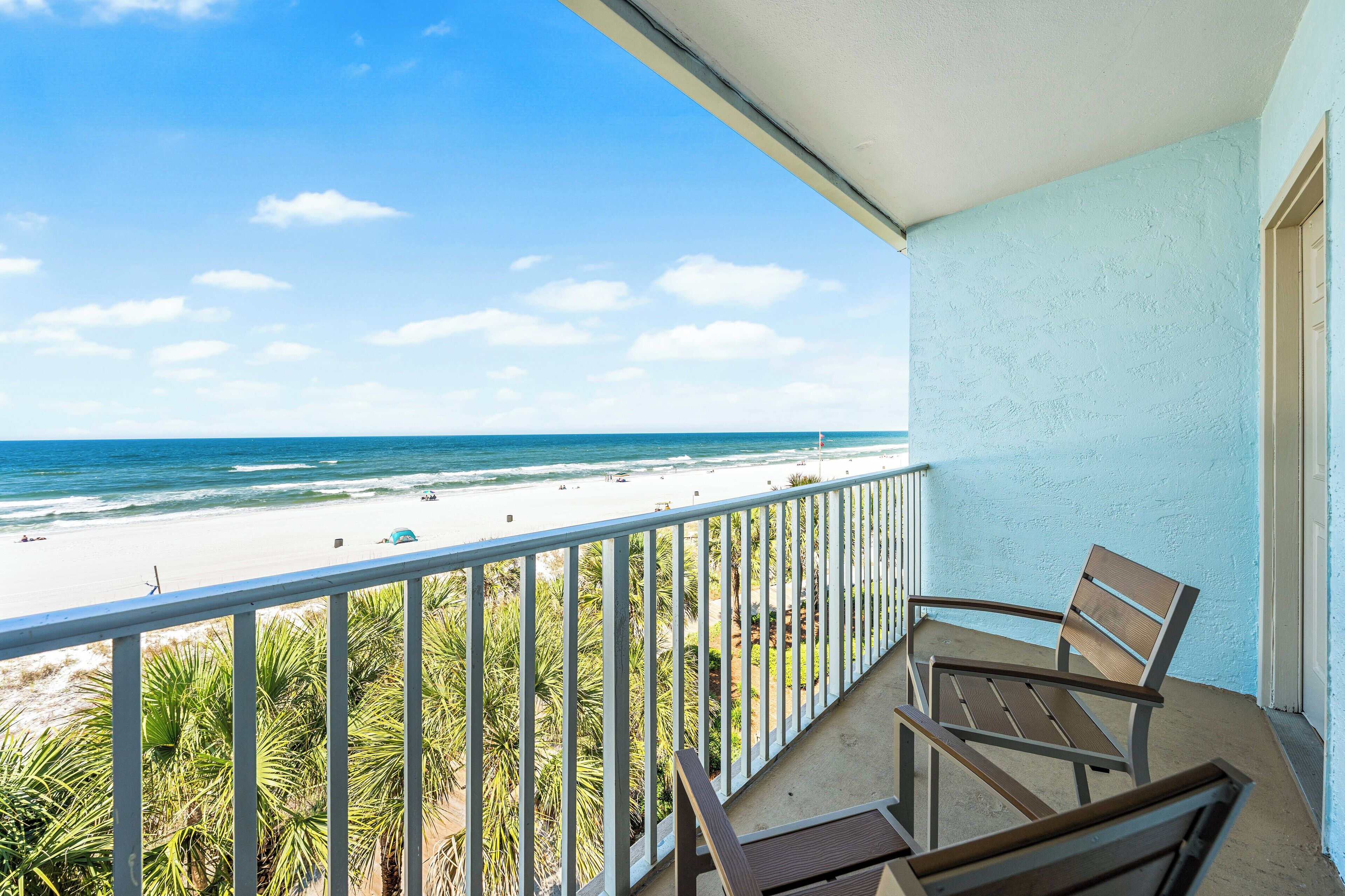 A balcony with a view of a beach and ocean.