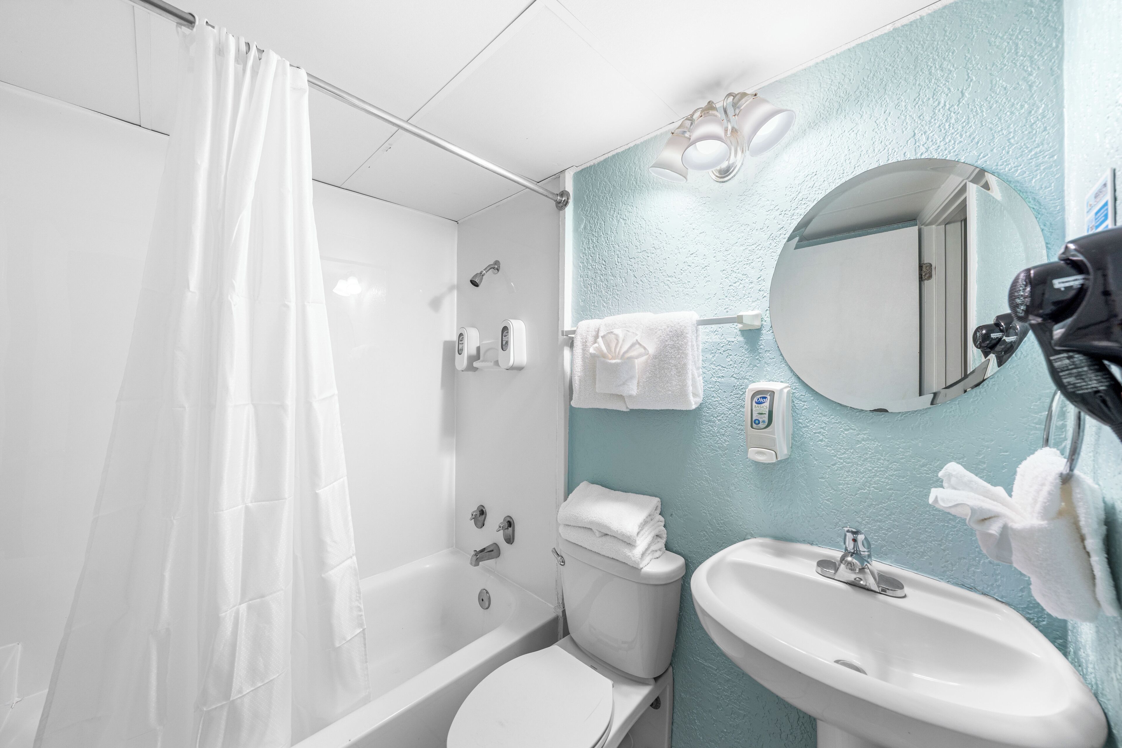 Une salle de bain avec une baignoire, des toilettes, un lavabo et un miroir.