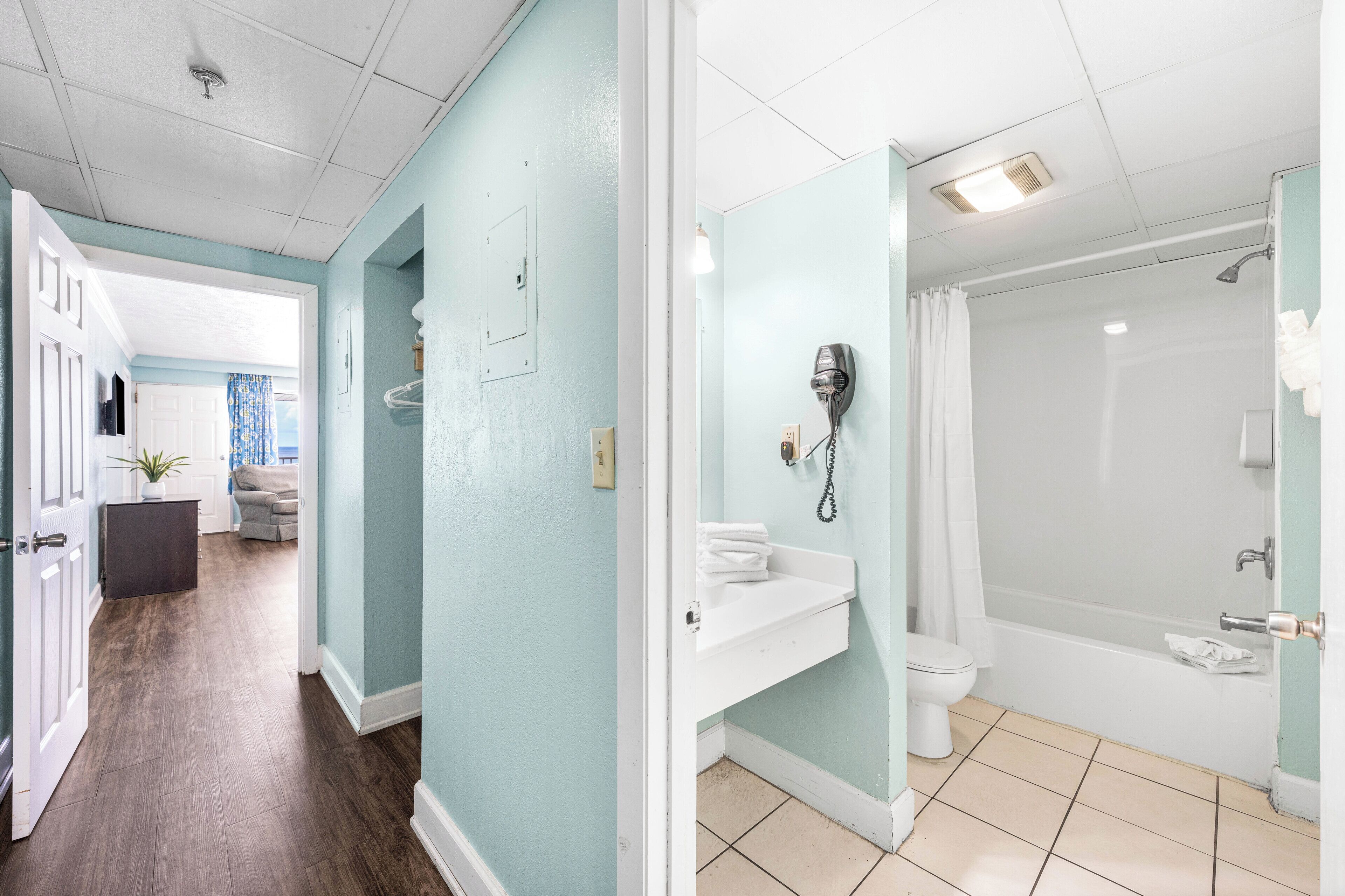 A bathroom with a shower, toilet, and hairdryer.
