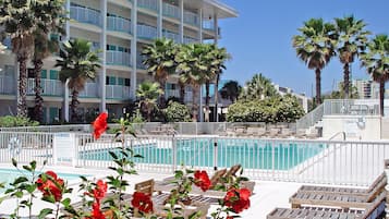 Relax by the pool surrounded by lush greenery and enjoy the view of the nearby building.
