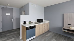 A modern kitchen with a dishwasher, microwave, and sink. - Studio 6 Suites Lake Havasu City, AZ  (Lake Havasu City)