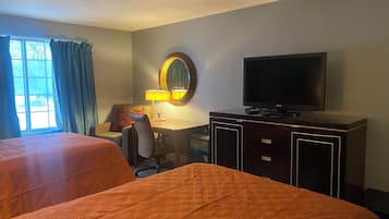 Een hotelkamer met twee bedden, een bureau met lamp, een televisie en een groot raam met gordijnen.