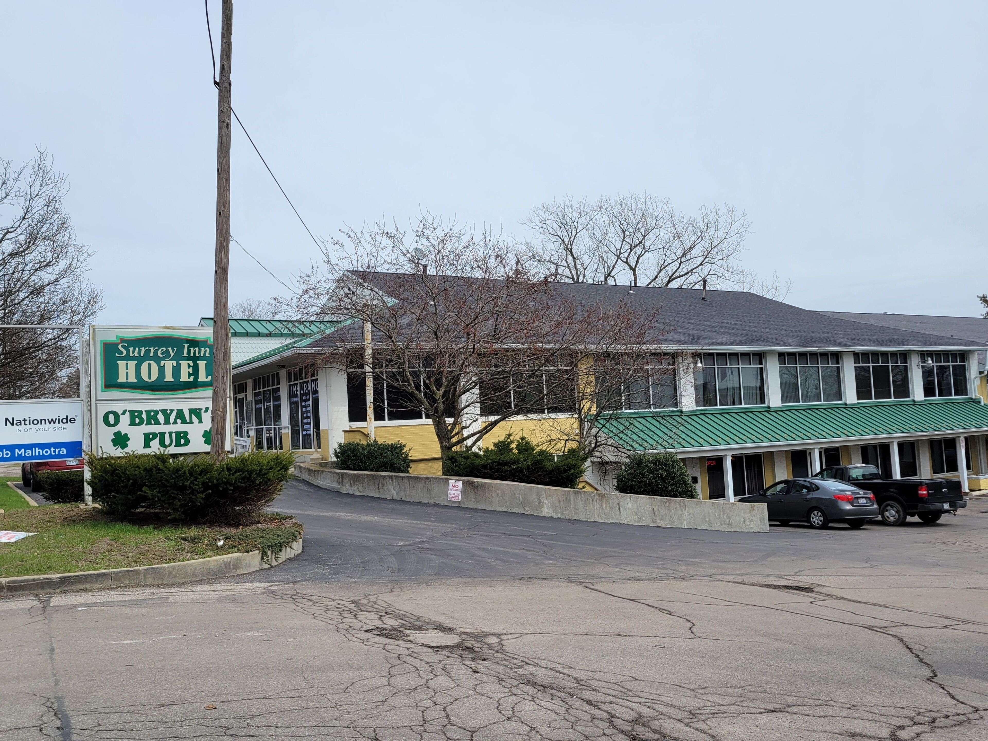 Un hotel con un tetto verde e un cartello per l'O'Bryan's Pub.