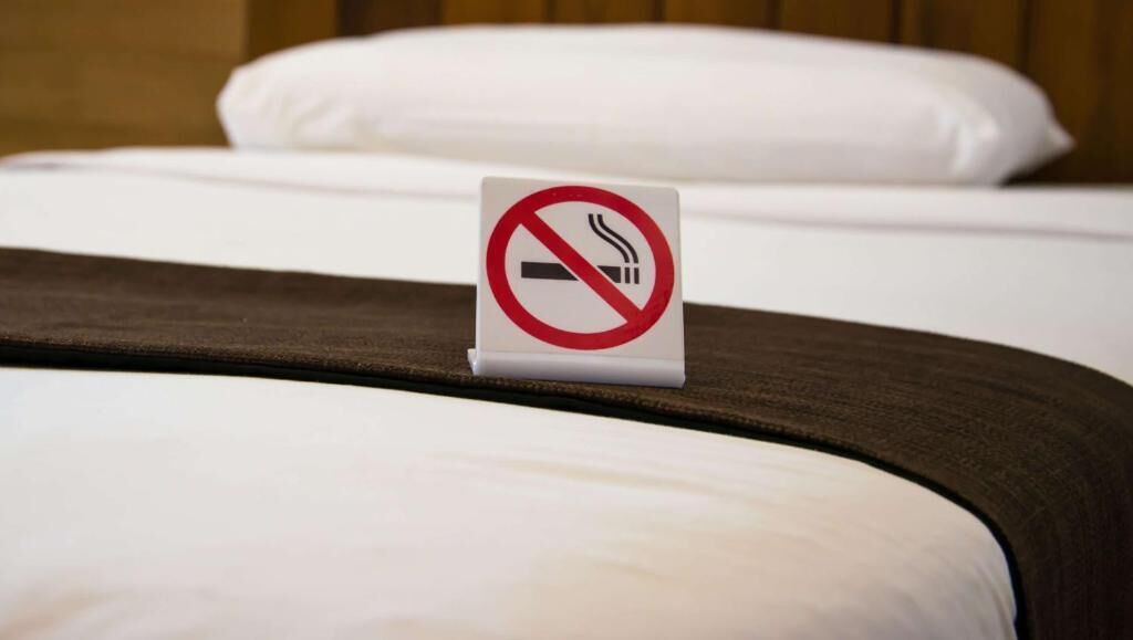 Ein Bett mit einem Rauchverbot-Schild am Kopfteil.