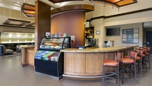 A bar area with a counter, seating, and a refrigerated display. - Hyatt Place Fremont/Silicon Valley (Fremont)