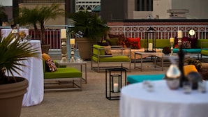 Un espace extérieur aménagé avec des tables, des chaises et des plantes en pot.