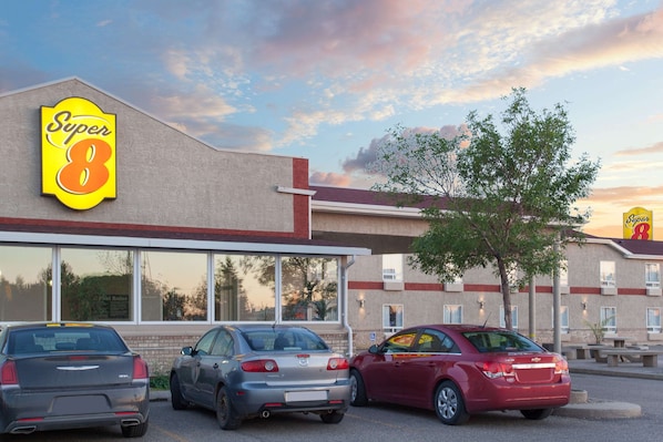 Un hotel Super 8 con tres coches estacionados adelante.