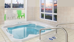 Un jacuzzi con vistas a un estacionamiento y un edificio con un letrero.