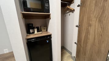 A compact kitchen with a microwave, coffee maker, and dishwasher.