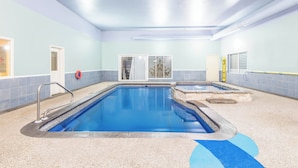 An indoor swimming pool with clear water, a lifeguard chair, and a safety ring. - Super 8 by Wyndham Cornwall ON (Cornwall)