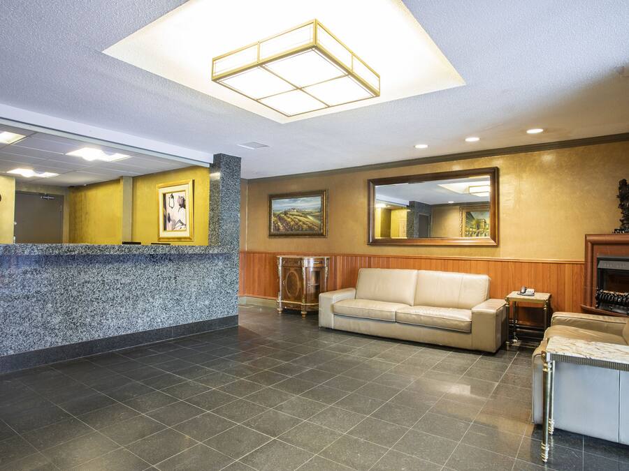 Aula, jossa on vastaanottotiski, sohva, sohvapöytä ja takka.