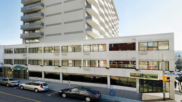 A multi-story hotel with a flat facade, multiple balconies, and a clear sky.