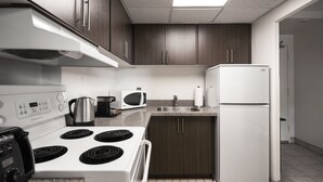 Una cocina moderna con estufa, microondas y refrigerador blancos.