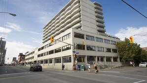 A multi-story building with a modern architectural design, featuring balconies and large windows.