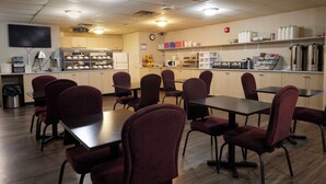 A restaurant with tables and chairs, a kitchen area, and various appliances.