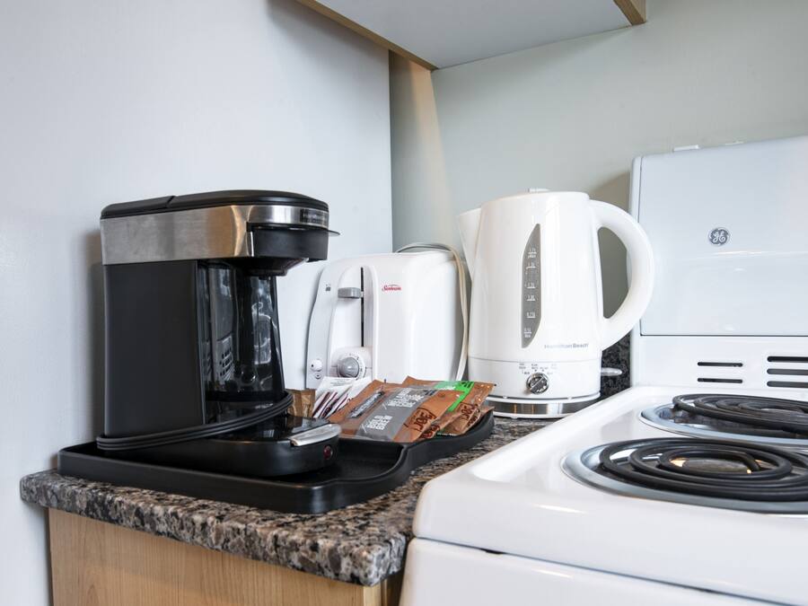 Eine Küche mit Kaffeemaschine, Toaster und Wasserkocher auf der Arbeitsfläche.