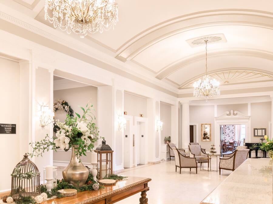 A spacious lobby with a marble reception desk, elegant chandeliers, and comfortable seating areas.