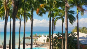 A resort with a pool, palm trees, and a view of the ocean. - Karibea Beach Resort Gosier, Residence Prao (Le Gosier)