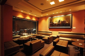 A hotel room with a city view, a large painting, and a seating area with tables and sofas. - Crowne Plaza ANA Kushiro by IHG (Kushiro)