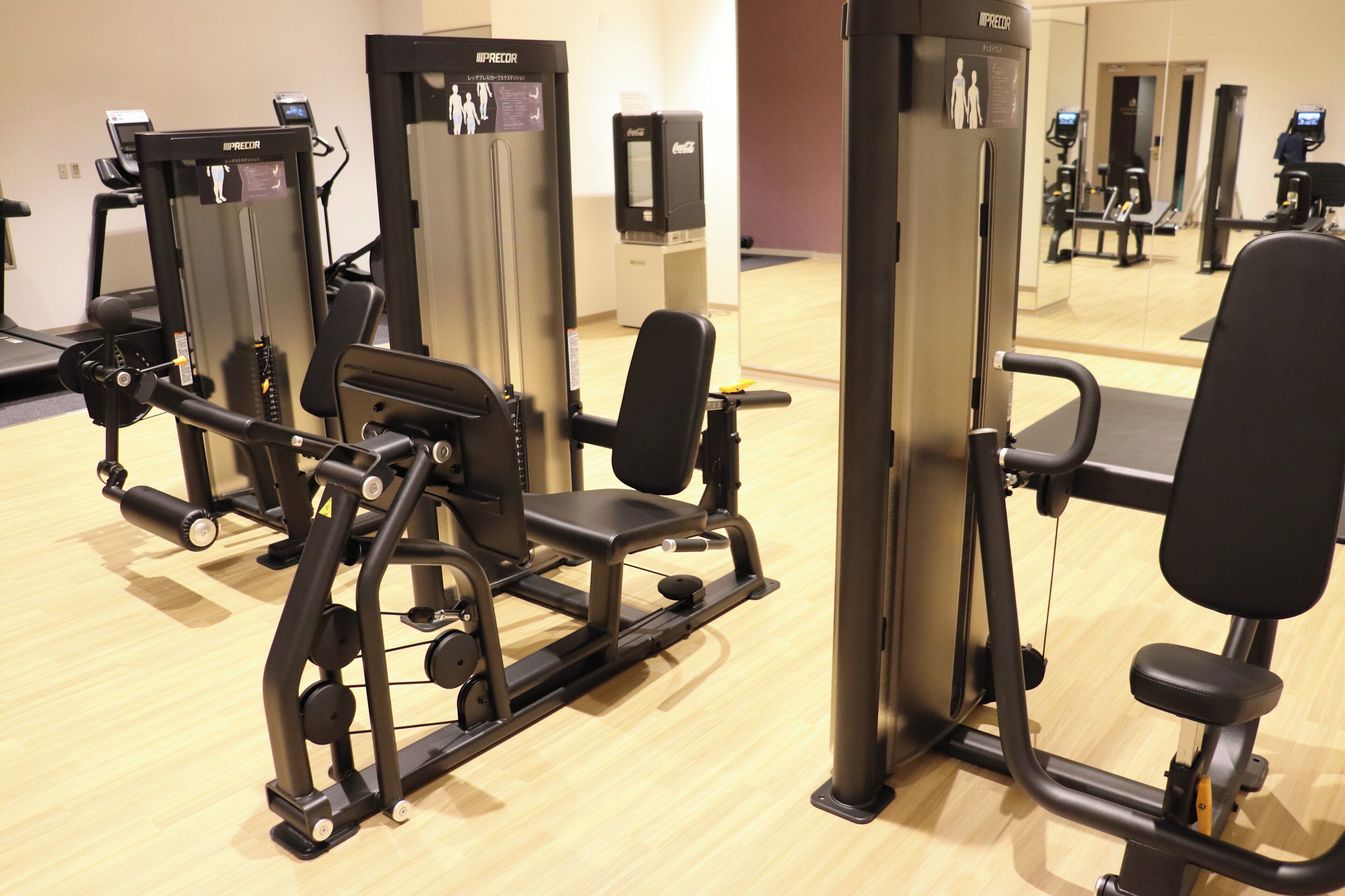 A gym with various exercise machines, including a leg press and a chest press.