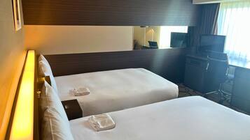 A hotel room with two beds, a desk, a chair, a TV, and a window with curtains.