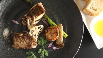 A plate with grilled meat, mushrooms, asparagus, and a garnish of parsley.