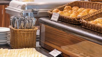 Buffet com diversos alimentos, incluindo pão, doces e carnes.