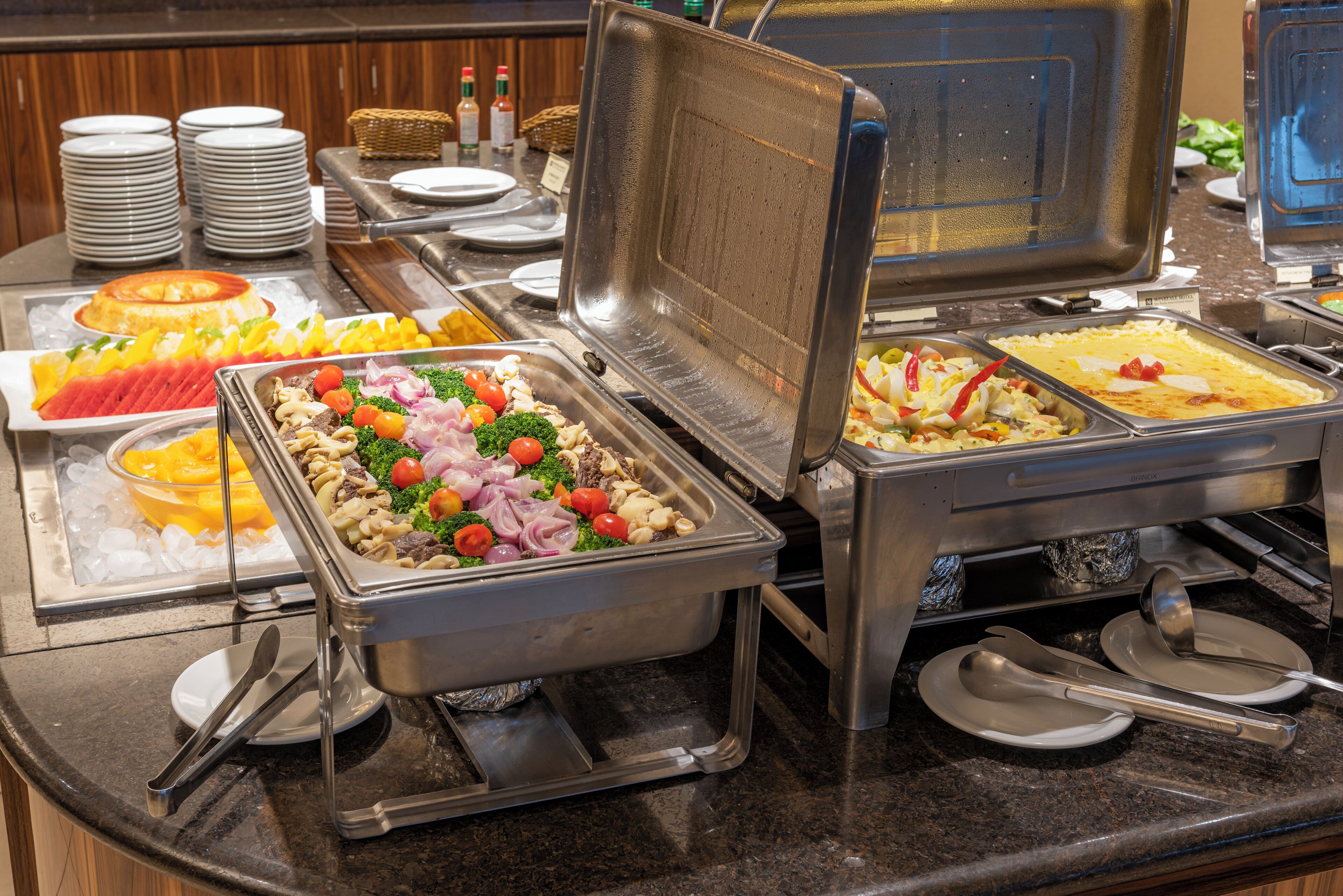 A buffet with various food items and utensils.