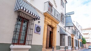 Un edificio con un toldo a rayas, una puerta de madera y un letrero que dice 