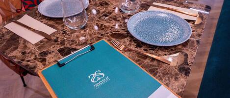 A table set with plates, cutlery, and a menu.