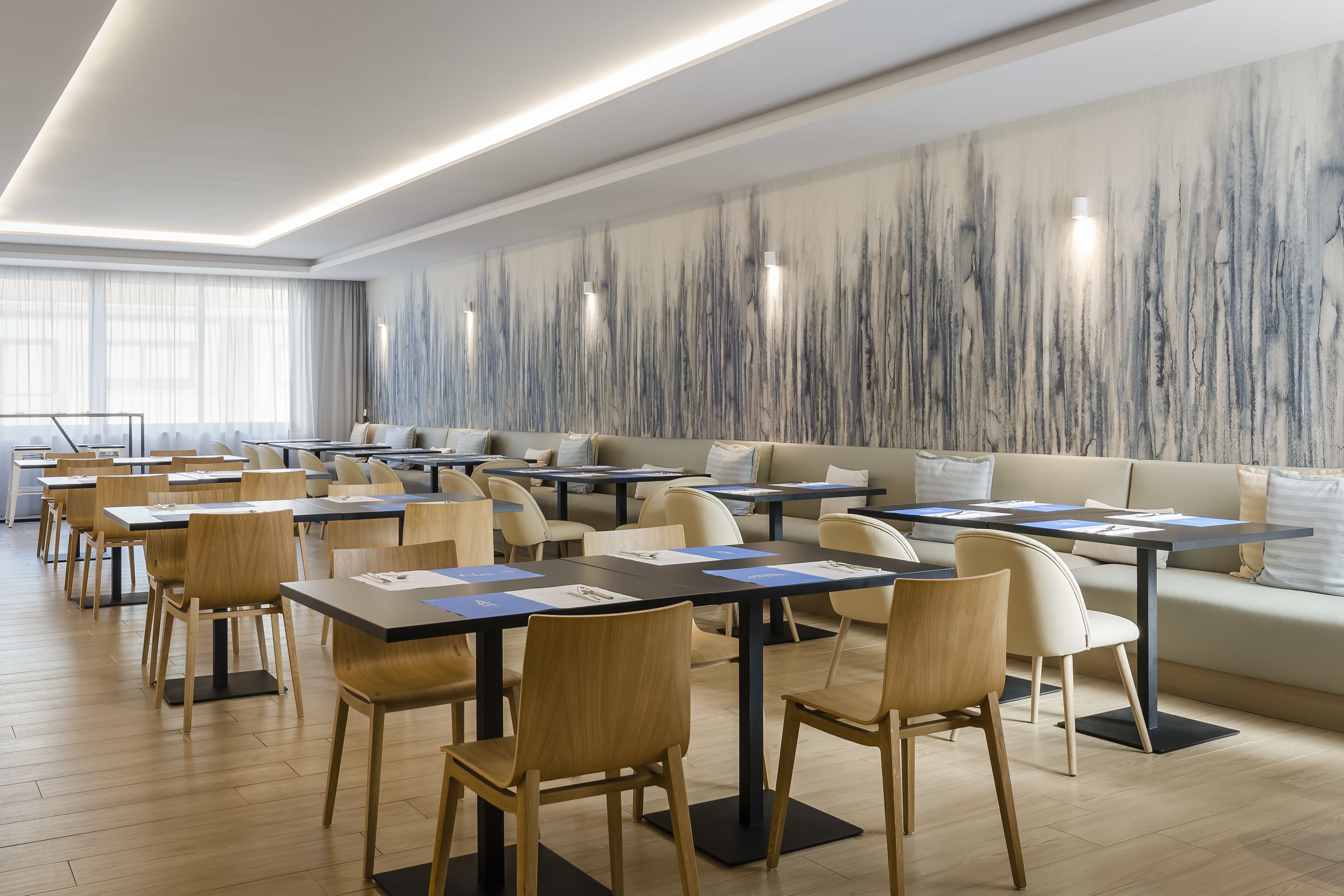 A modern conference room with tables, chairs, and a sofa.