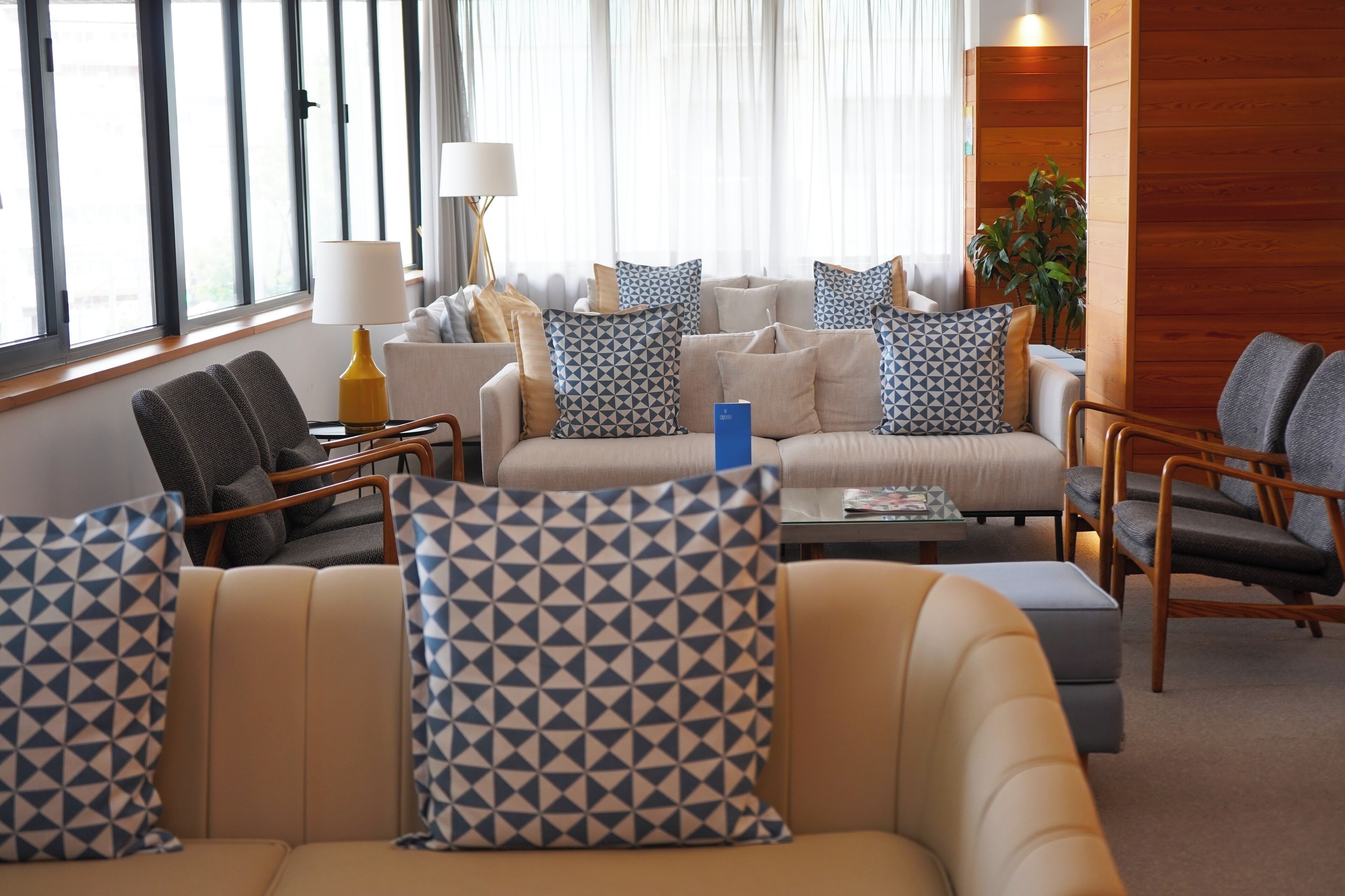 Une chambre d’hôtel moderne, dotée d’un canapé, de fauteuils et d’une table basse.